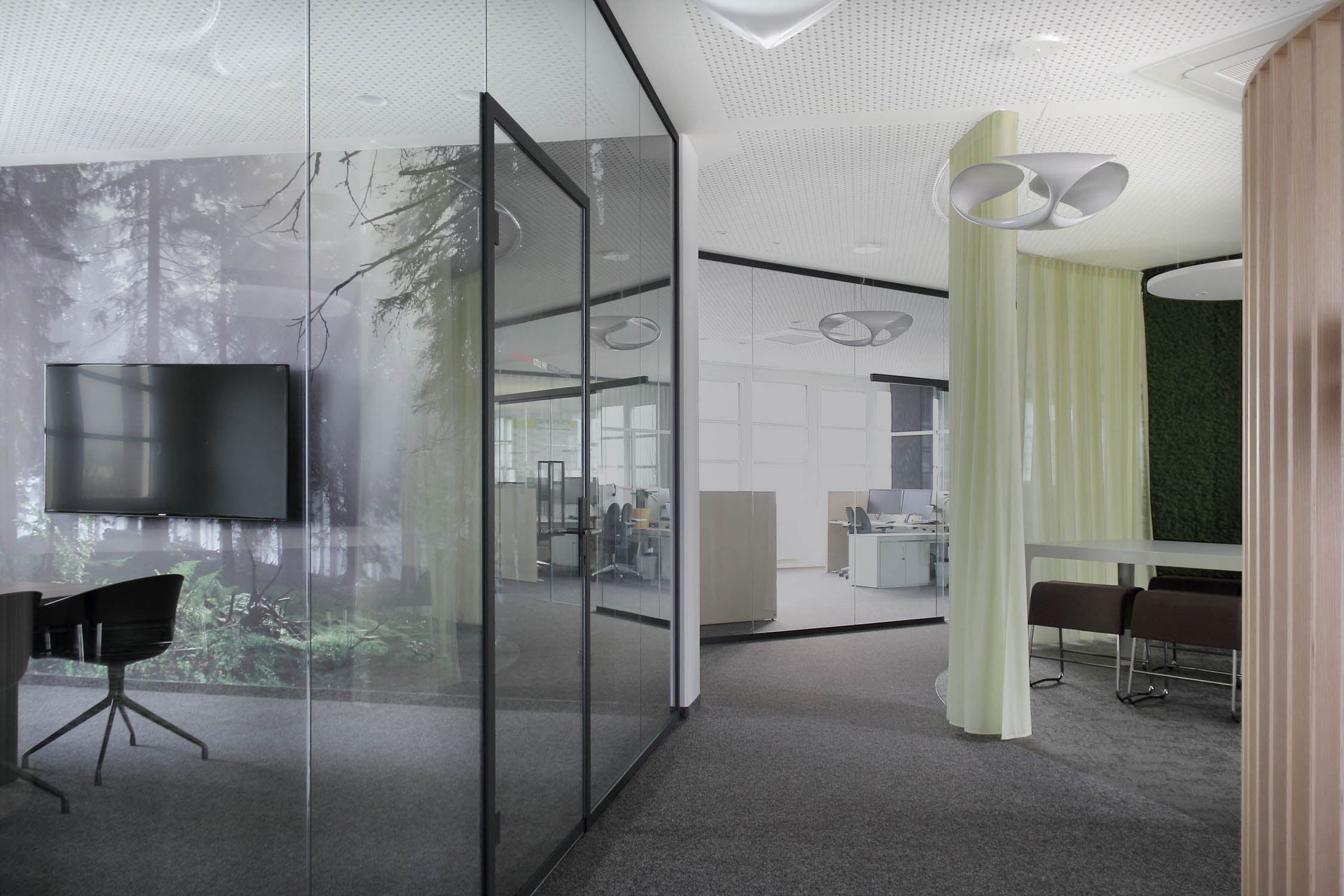 Light-filled Brainlab workspace with glass walls, curtains and white pendant lights