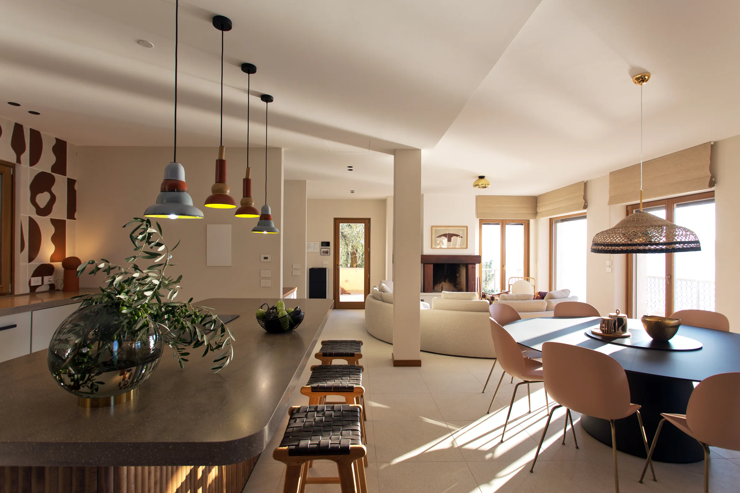 Open-plan living, dining and kitchen area at Villa Celeste with warm natural tones and sculptural lighting